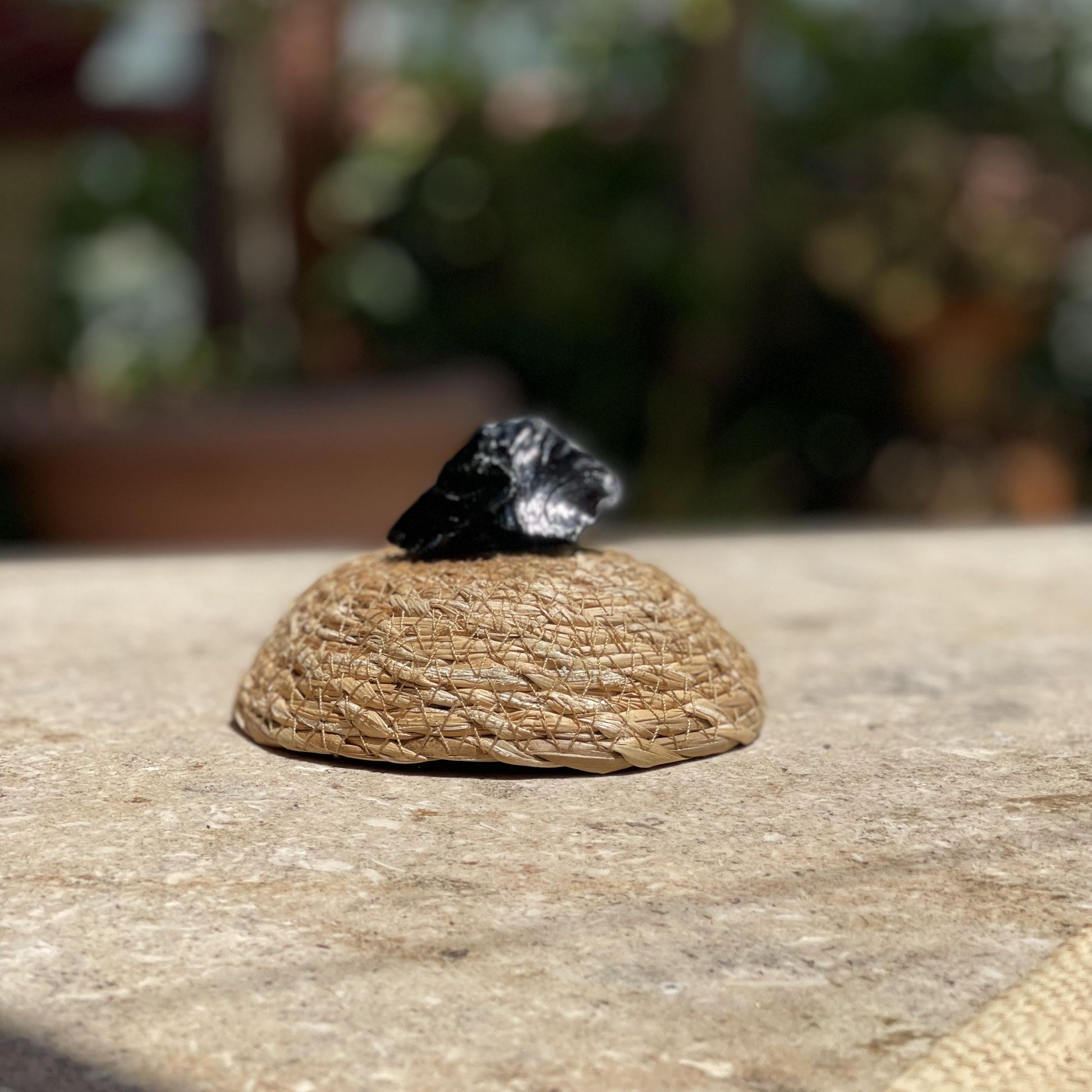 Raw Black Obsidian bodyguard stone in a protective glass dome for spiritual protection and meditation.