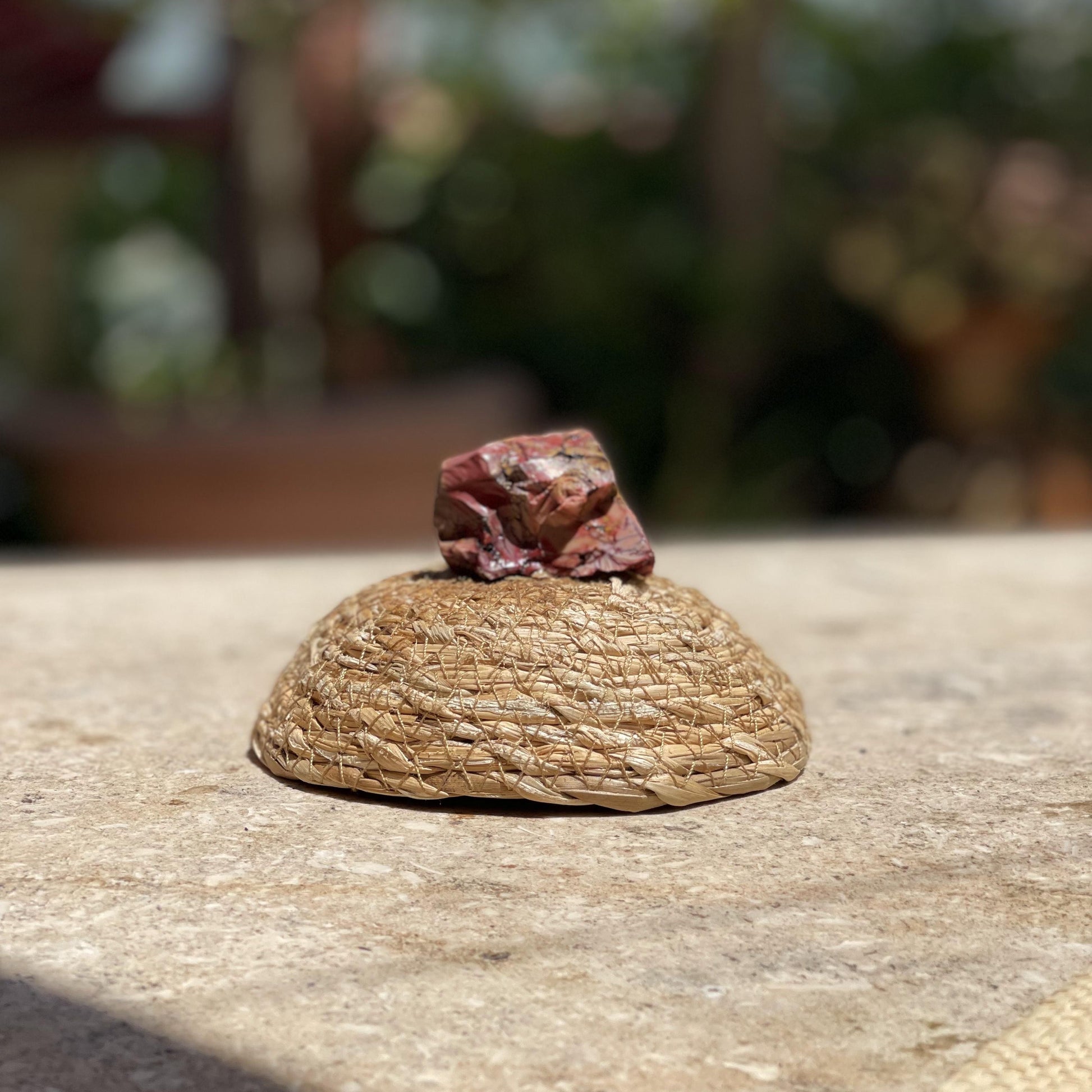 Raw Dragon Blood Stone courage crystal in a protective glass dome for inner strength and nature-inspired meditation
