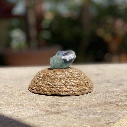 Raw Rainbow Fluorite focus stone in a protective glass dome for mental clarity and colorful meditation decor.