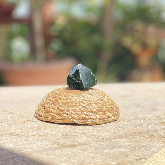 Raw Red Agate energy stone in a protective glass dome for strength, vitality, and deep green nature decor.