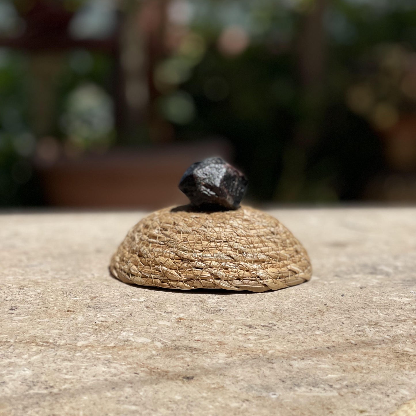 Raw Shungite shield stone in a protective glass dome for EMF protection and grounding meditation.